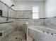 Bathroom featuring tiled shower and separate tub with mosaic tile accents and neutral color palette at 2528 Double Tree Pl, Oviedo, FL 32766