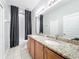 Bathroom featuring double vanity with granite countertop, full tub and shower, and large mirror at 2528 Double Tree Pl, Oviedo, FL 32766