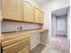 Bright laundry room features wood cabinets, tiled countertops, washer and dryer hookups and access to the main house at 2528 Double Tree Pl, Oviedo, FL 32766