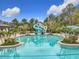 Community pool with water slide, lounge chairs, palm trees and landscaping at 2528 Double Tree Pl, Oviedo, FL 32766