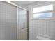 Tiled shower with glass doors next to a window at 2666 Derbyshire Rd, Maitland, FL 32751