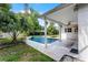 A covered patio with a ceiling fan overlooks a pool and landscaped backyard oasis at 2666 Derbyshire Rd, Maitland, FL 32751