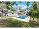 Backyard view showcases a refreshing pool surrounded by lush greenery and a white home at 2666 Derbyshire Rd, Maitland, FL 32751