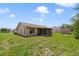 Backyard featuring a screened-in porch, green grass, and a wooden shed at 2880 Trenton Ln, Deltona, FL 32738