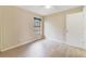 Cozy bedroom with light wood floors, a window with blinds, and a white door at 2880 Trenton Ln, Deltona, FL 32738