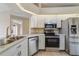 Well-equipped kitchen with stainless steel appliances, white cabinetry, and granite countertops at 2880 Trenton Ln, Deltona, FL 32738