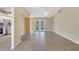 Open living room area with wood floors, ceiling fan, adjacent to a kitchen and French doors at 2880 Trenton Ln, Deltona, FL 32738