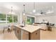 Modern kitchen features an island with seating, stainless steel appliances, and views of dining area and living room at 3022 Peel Ave, Orlando, FL 32806