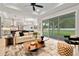 Bright living room boasts a ceiling fan, neutral tones, patio access, and view into a well appointed kitchen at 3022 Peel Ave, Orlando, FL 32806