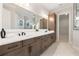 Main bathroom features dual vanities, stone countertops, and a glass-enclosed shower with a tiled surround at 3022 Peel Ave, Orlando, FL 32806