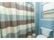 Bathroom featuring a toilet, window, and a tub and shower with striped curtain at 319 Morning View Dr, Winter Garden, FL 34787