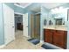 Bright bathroom with blue walls, tiled floor, glass enclosed shower, and a wood vanity at 319 Morning View Dr, Winter Garden, FL 34787