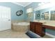 Bathroom with a corner tub, vanity with a tan countertop, and natural light at 319 Morning View Dr, Winter Garden, FL 34787