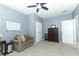 Cozy bedroom featuring a ceiling fan, sofa and a whiteboard, offering a relaxing space to unwind at 319 Morning View Dr, Winter Garden, FL 34787