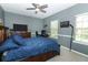 Well-lit bedroom featuring a comfortable bed, a ceiling fan, and lots of light from two windows at 319 Morning View Dr, Winter Garden, FL 34787