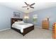 Bedroom with soft carpet, ceiling fan, a dark wood bed and light wood dresser, creating a cozy retreat at 319 Morning View Dr, Winter Garden, FL 34787