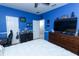 Bright bedroom features a blue accent wall, ceiling fan and decorative shelving at 319 Morning View Dr, Winter Garden, FL 34787