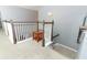 Upstairs hallway features white and wood banister, carpet and a small table at 319 Morning View Dr, Winter Garden, FL 34787