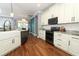 Well-equipped kitchen featuring white cabinets, granite counters, modern appliances, and hardwood floors at 319 Morning View Dr, Winter Garden, FL 34787