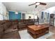 Inviting living room featuring a comfortable leather sectional, a wooden coffee table, and an open layout to the kitchen at 319 Morning View Dr, Winter Garden, FL 34787