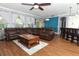 Spacious living room with a large brown leather sectional sofa, wood floors, and a view into the dining area at 319 Morning View Dr, Winter Garden, FL 34787