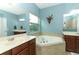 Main bathroom with a corner soaking tub, double sinks, a shower and a window at 319 Morning View Dr, Winter Garden, FL 34787