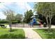 Community playground with slides and climbing structure in fenced area and lush green surroundings at 319 Morning View Dr, Winter Garden, FL 34787