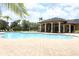 Community pool with plenty of seating, a covered patio area, and lush tropical landscaping at 319 Morning View Dr, Winter Garden, FL 34787