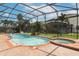 Pool and hot tub with screened enclosure includes a basketball hoop, fountains, and views of the lush backyard at 319 Morning View Dr, Winter Garden, FL 34787