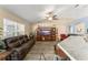 Comfortable living room with wood-look tile flooring, a ceiling fan, and access to the kitchen at 3342 Sanborn Ln, Deltona, FL 32738
