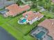 Aerial view of home with a pool, spa, landscaped yard, and clay tile roof in a residential neighborhood at 4031 Bermuda Grove Pl, Longwood, FL 32779