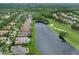 An aerial view of a residential area highlighting homes near a lake and golf course surrounded by trees at 4031 Bermuda Grove Pl, Longwood, FL 32779