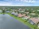 Aerial view showcasing houses with pools along the lake under a cloudy sky in a Florida neighborhood at 4031 Bermuda Grove Pl, Longwood, FL 32779