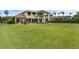 A spacious backyard with a large lawn and mature landscaping extends from the covered patio and pool area at 4031 Bermuda Grove Pl, Longwood, FL 32779