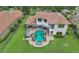 Aerial view of backyard featuring a pool, spa, and outdoor seating on a meticulously manicured lawn at 4031 Bermuda Grove Pl, Longwood, FL 32779