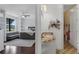 Bathroom showing sink and vanity next to a bedroom with a sofa, shelves and view of the lake at 4031 Bermuda Grove Pl, Longwood, FL 32779