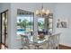 Light and airy dining room with a pool view, modern chandelier and glass table at 4031 Bermuda Grove Pl, Longwood, FL 32779