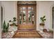 Elegant wood double doors welcome you with decorative plants and a 'Welcome' mat at 4031 Bermuda Grove Pl, Longwood, FL 32779