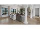 Open-concept living area with white columns, a fireplace, and expansive views of the outdoor pool area at 4031 Bermuda Grove Pl, Longwood, FL 32779