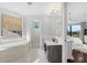 Bright bathroom featuring dual sinks, tub, and a large window letting in natural light at 4031 Bermuda Grove Pl, Longwood, FL 32779