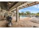 Spacious patio with an outdoor grill, dining area, and views of the pool and lush landscape at 4031 Bermuda Grove Pl, Longwood, FL 32779