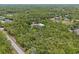 An aerial view of a home with a metal storage building surrounded by lush green trees providing privacy at 41128 Apple St, Eustis, FL 32736