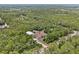 An aerial view of a home with a metal storage building surrounded by lush green trees providing privacy at 41128 Apple St, Eustis, FL 32736