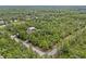 An aerial view of a home with a metal storage building surrounded by lush green trees and near a corner lot at 41128 Apple St, Eustis, FL 32736