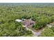 An aerial view of a home with a metal storage building surrounded by lush green trees providing privacy at 41128 Apple St, Eustis, FL 32736