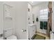 Bathroom with white vanity, green towels, medicine cabinet, and a toilet behind the doorway at 41128 Apple St, Eustis, FL 32736