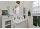 Bathroom featuring a white vanity, circular mirror, and a small window above the toilet at 41128 Apple St, Eustis, FL 32736