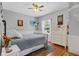 Cozy bedroom featuring a bed, dresser, mounted TV, window and wood floors at 41128 Apple St, Eustis, FL 32736