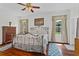 Bedroom featuring a large bed, wood floors, windows with curtains, and blue patterned rugs at 41128 Apple St, Eustis, FL 32736