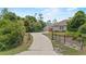 Long driveway leading to a well-maintained home and detached garage, surrounded by lush landscaping at 41128 Apple St, Eustis, FL 32736